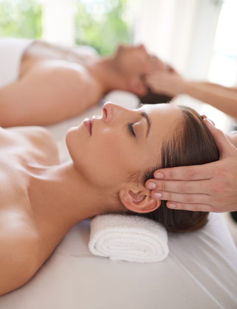 Enjoying a day of pampering. A husband and wife receiving head massages.